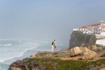 ポルトガルのアゼーニャス・ド・マールのの崖の上に立つ人々