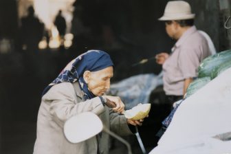 China-Urumchi-Tian Chi Lu market-an old woman-melon-eating