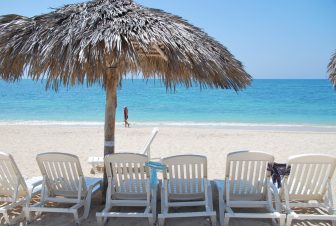 the parasol and deck chairs on the beach of Playa Ancon in Cyba