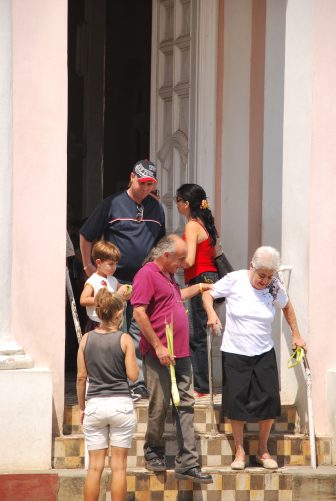 people coming out of the pink church after the mass in Rodas, Cuba