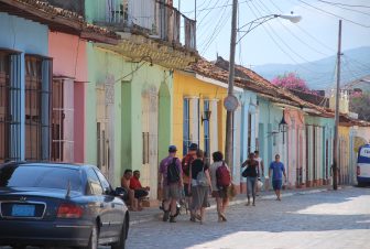 the colourful houses along the road with people in Trinidad in Cuba