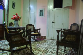 a colonial style room with chairs and the tiled floor in the residential house in Trinidad, Cuba