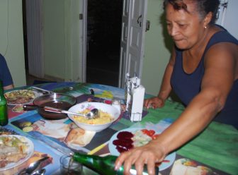 a woman serving foods on the table in her house in Trinidad, Cuba