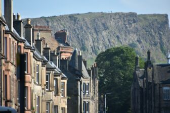 people walking on top of Arthur's Seat seen at the bus stop towards Leith