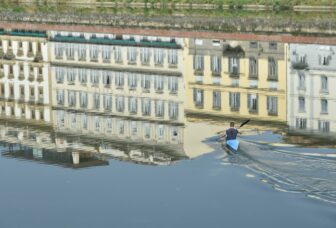 the reflections on Arno River and a canoe rower