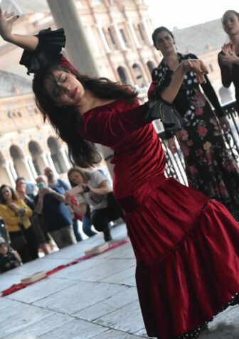 a flamenco dancer in red at Plaza de España in Seville