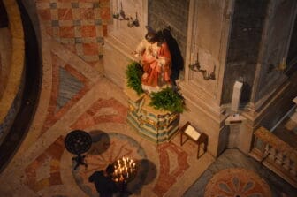 Un uomo accende una candela nella basilica