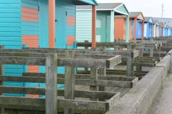 a row of beach hut along the sea in Whitstable