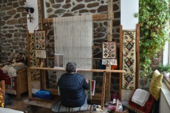 ブルガリア、チプロフツィのゲストハウスでキリムを織るお婆さん