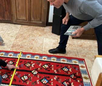 ブルガリア、チプロフツィのゲストハウスで織られたキリムの寸法を測る