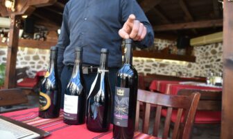 ブルガリア、メルニックのレストラン「アレクソヴァ・クシュタ」でワインを説明するウエイター
