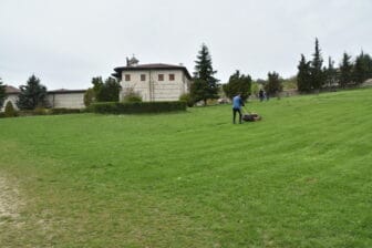 ブルガリア、ロジェン修道院の外で芝刈りをする人