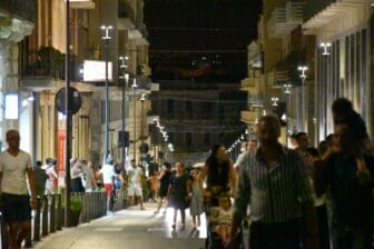 many people walking in the main street in Syracuse at night