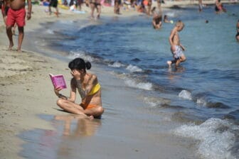 una ragazza legge sulla spiaggia