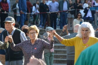 Le facce delle persone che ballano la danza della Sardana