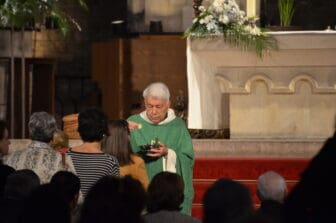the priest in green in Basilica de Santa Maria del Mar in Barcelona, Spain