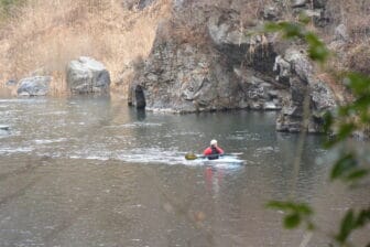 a person canoeing on the river near the sake brewery 