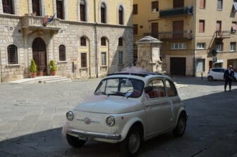 an old Fiat 500 parked outside of Collegiata di Santa Maria Assunta in Poggibonsi, a town in Tuscany, Italy