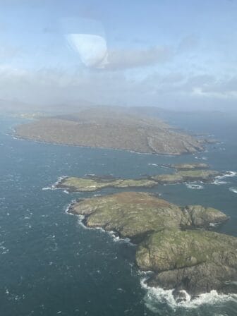 スコットランド、ヘブリディーズ諸島のバラ島のビーチに向かうプロペラ機から見下ろした島々