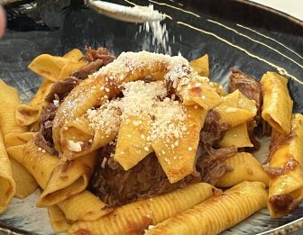 homemade macaroni with pork sauce in the restaurant called Ma Lo' in Carpi, Italy