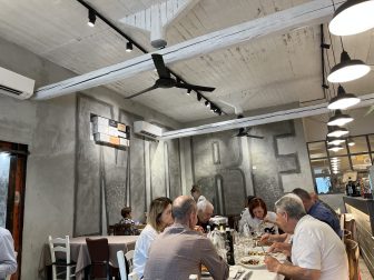 イタリアのエミリア・ロマーニャ州、カルピ郊外のレストラン、Trattoria Il Torchietto で食事をする人々