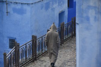 モロッコのシャウエンを歩くジェラバ姿の人