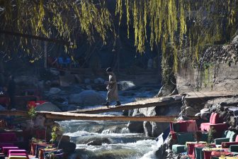 a man crossing the river in Setti Fatma in Ourika Valley in Morocco